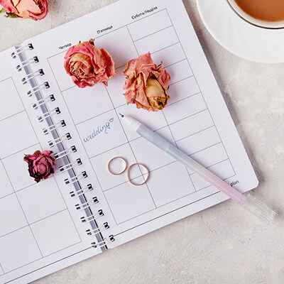 wedding planning, notebook, wedding rings and a pen